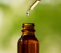 Dropper With Amber Bottle and Green Background